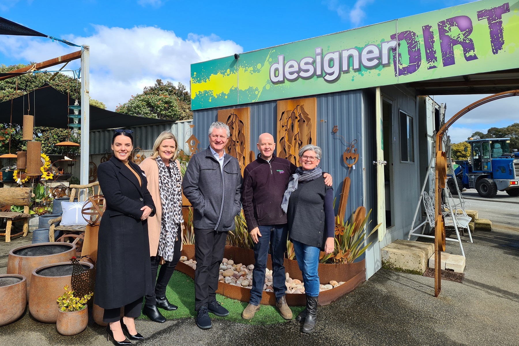 Photo of SBDC Board Members Eliza Carbines and Gillian Nathan, Small Business Commissioner David Eaton PSM and Jane and Ian Michael, owners of Designer Dirt, out the front of their business.