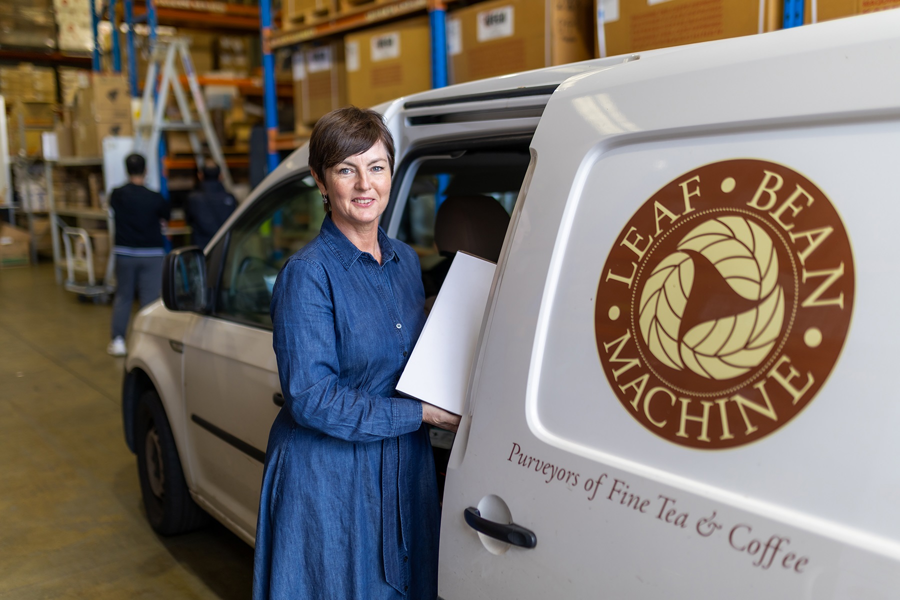 Photo of Fleur Cassidy, owner of Leaf Bean Machine. She is standing next to one of their delivery vans.