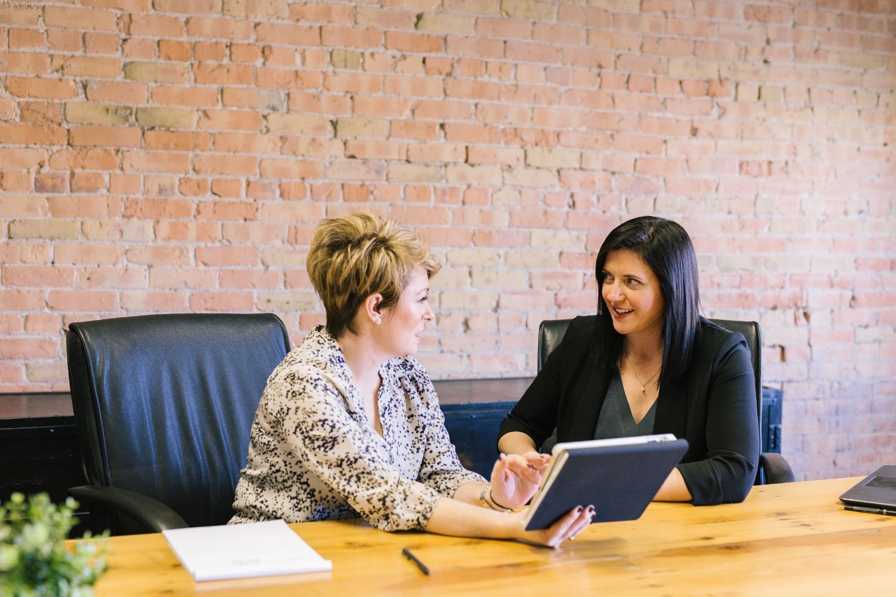 Photo of two women having a discussion in a meeting room.