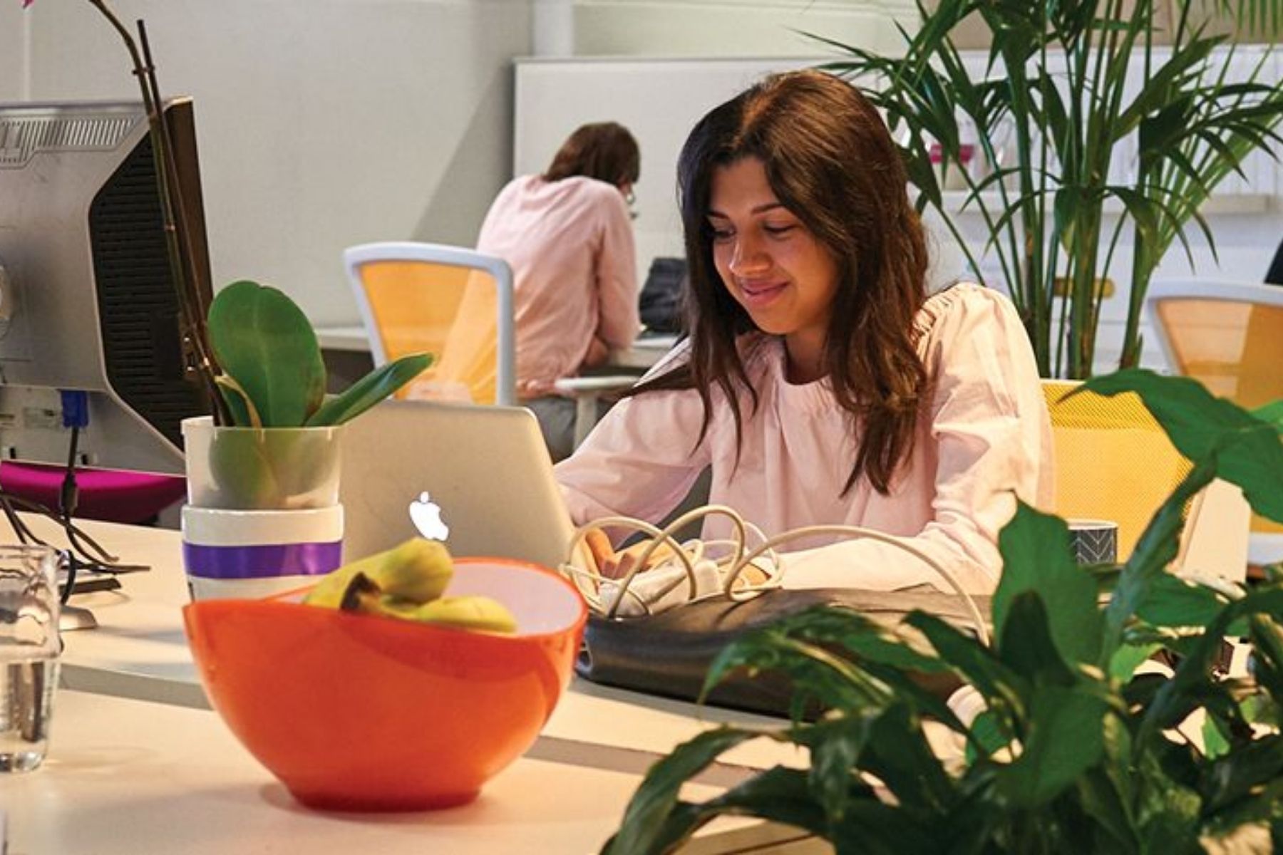 Photo of  woman working on a laptop in a co-working space.
