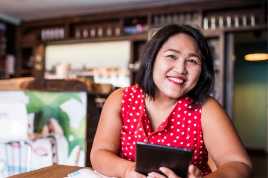 Photo of a restaurant owner holding a tablet device.