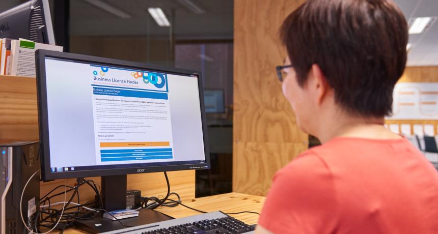 Photo of a woman using the SBDC's free Business Licence Finder to find the licences and permits needed to operate a business.